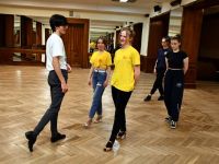Grupa młodzieży tańca towarzyskiego ćwicząca układ taneczny