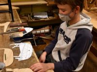 Chłopiec pracujący przy drewnianych elementach modelu statku