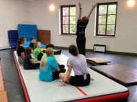 ćwicząca grupa dziewcząt z trenerem - akrobatyka