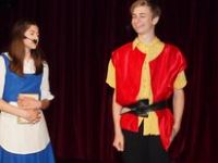 chłopiec i dziewczyna śpiewający w kostiumach na scenie