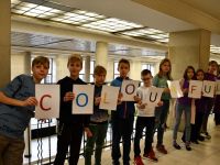 Grupa dzieci trzyma kartki z napisem po angielsku - colourful ( kolorowy)