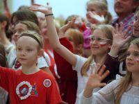 dzieci na scenie machają do zdjecia