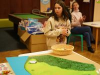 Dzieci wykonujące zadanie  podczas gry terenowej