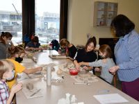 Grupa dzieci i instruktorka w pracowni ceramicznej