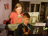 dwoje dzieci grających na keyboardach