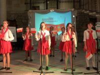 dzieci śpiewające w biało czerwonych strojach  piosenki patriotyczne