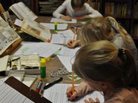 Dzieci piszące ćwiczenia z kaligrafii