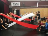 muzyka i instruktor tańca podpowiada dzieciom jak pracować z materiałem