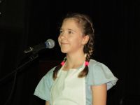 dziewczynka w stroju Dorotki przy mikrofonie.